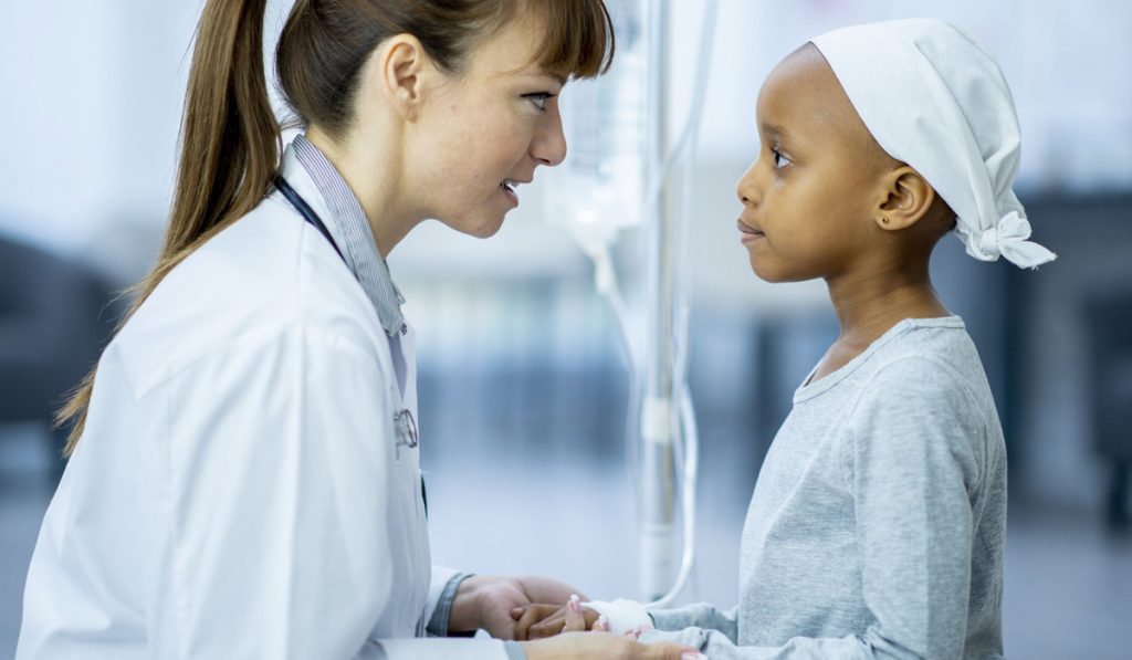Female healthcare provider with pediatric cancer patient