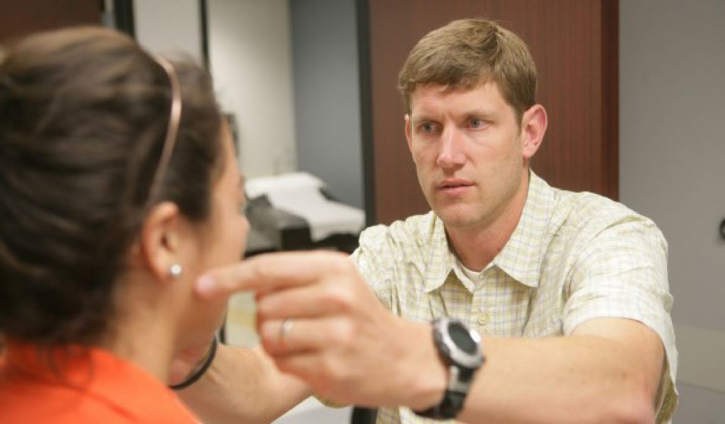 Andrew Gregory, M.D. evaluates a young patient for mTBI.