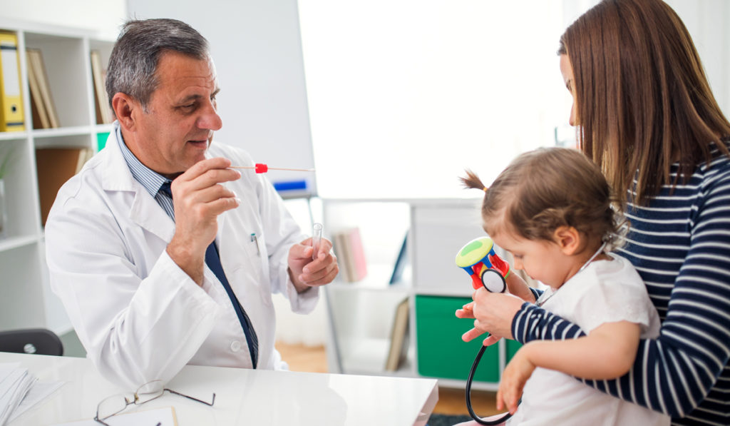 Physician using a saliva test on a pediatric patient.