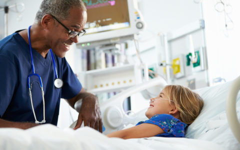 Doctor speaking to a child patient in ICU.