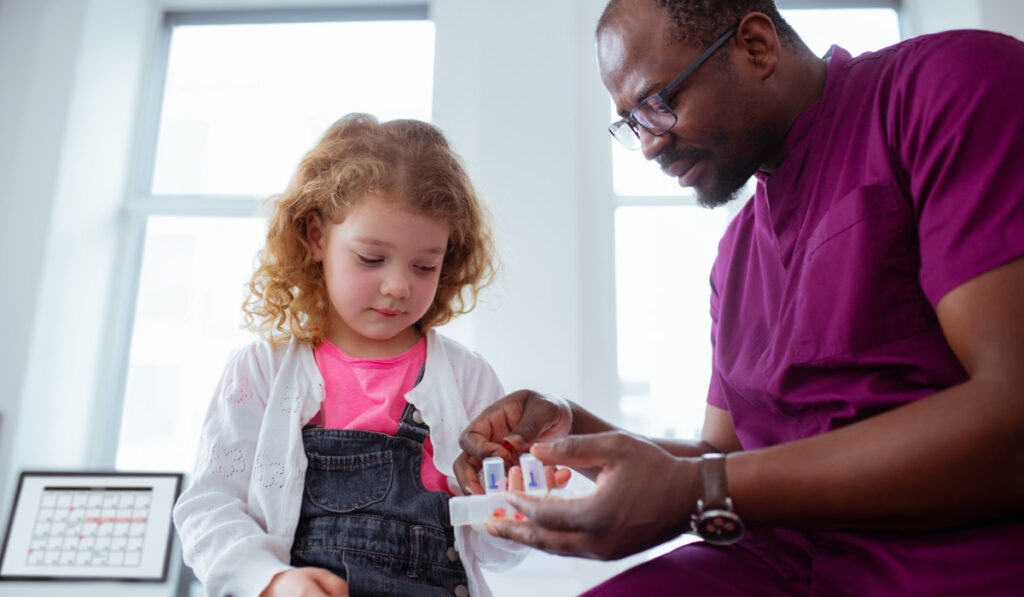 Doctor talking to child patient about medication.