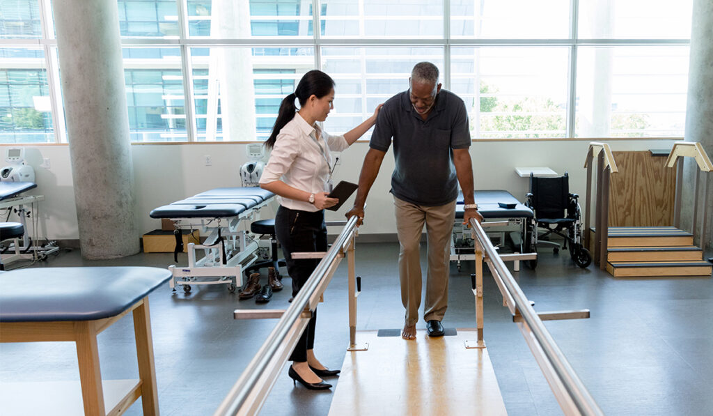Man walking with stabilizing bars in physical therapy
