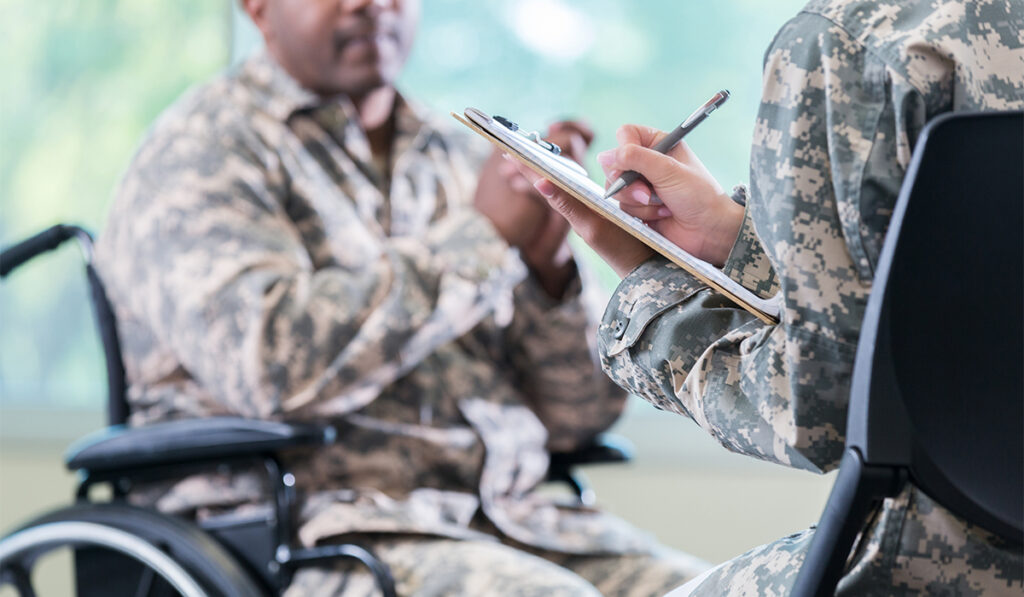 Disabled military member talking with to another military member.