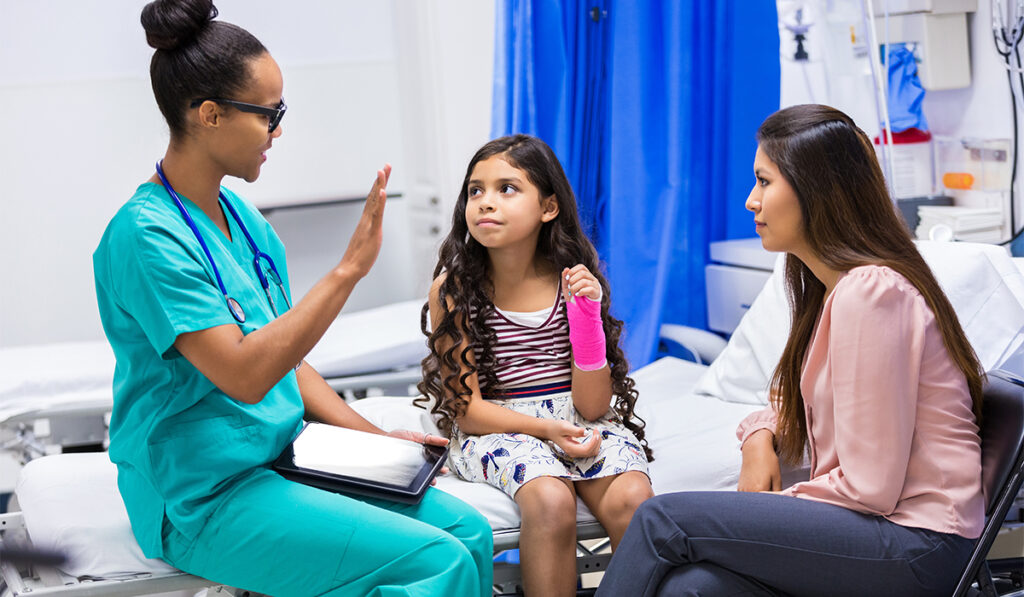Doctor talking to young patient and mother