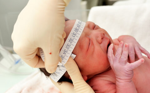 Newborn with head being measured