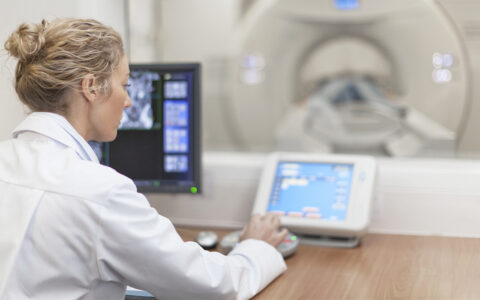 Female physician working MRI machine