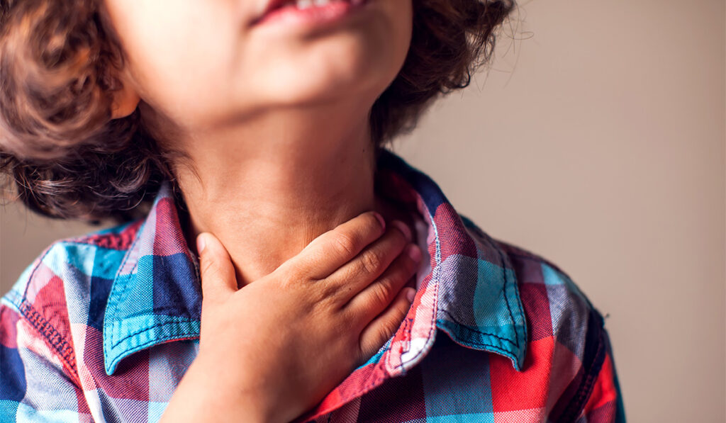 Child rubbing sore throat