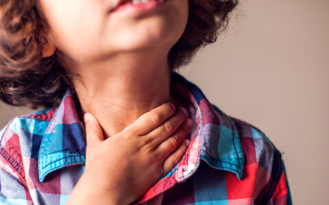 Child rubbing sore throat