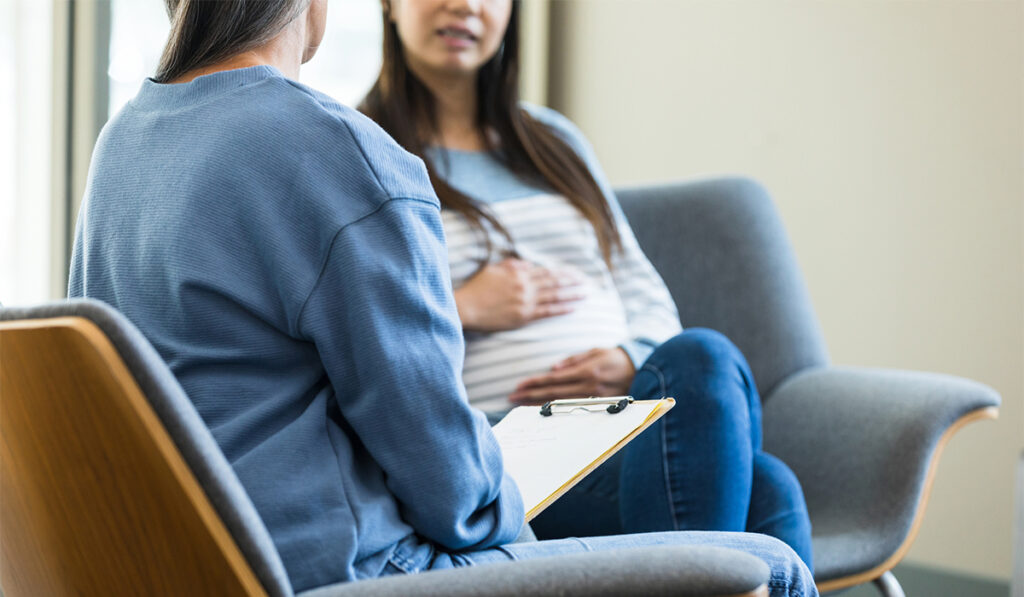 Pregnant woman talking with health care provider