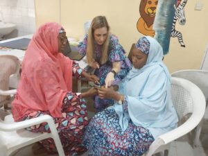 Lauren Klein, M.D., discusses sickle cell disease studies with colleagues in Nigeria
