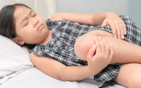 Child holding knee in pain