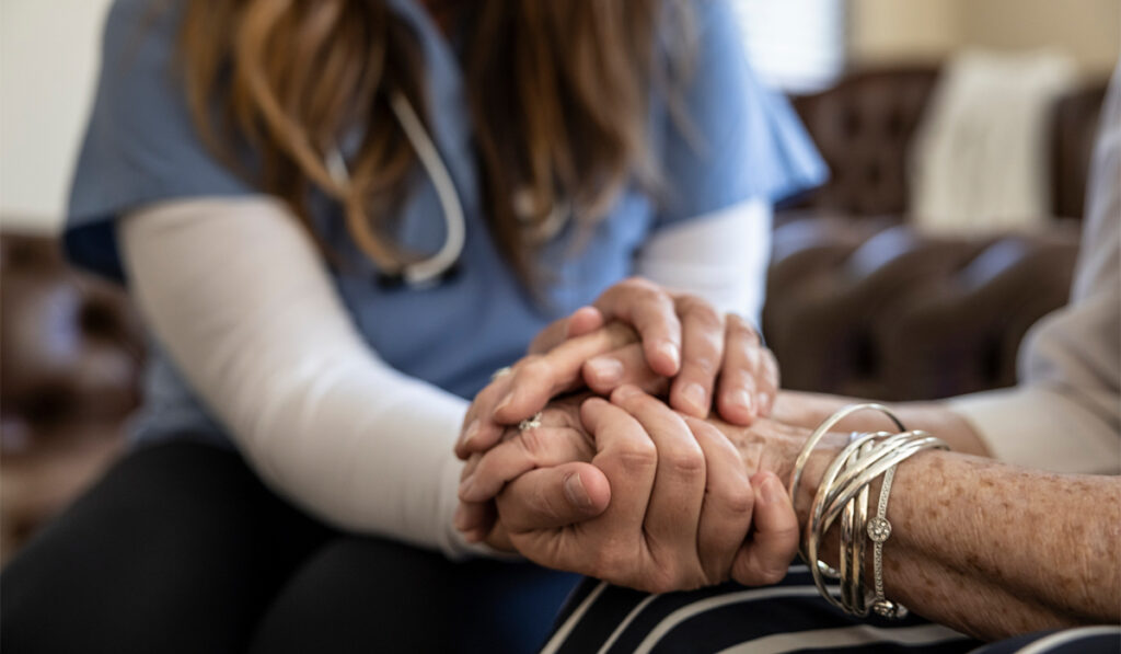 Holding hands in focus: an older adult and a health care worker