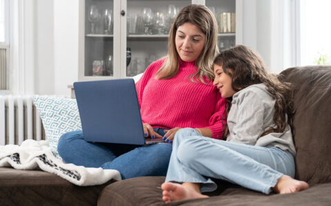 Mom and child on couch with laptop