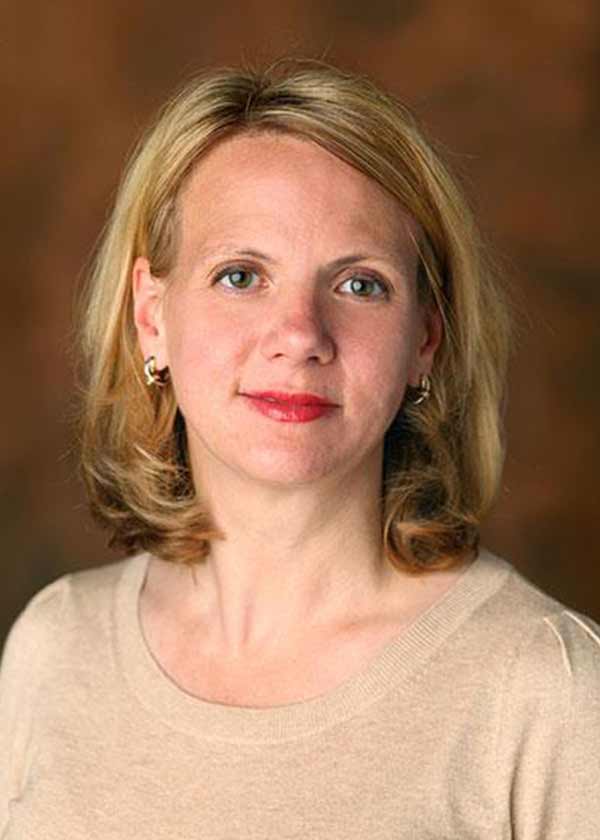 Portrait of Dr. Amanda Peltier, blond hair, red lipstick, tan shirt
