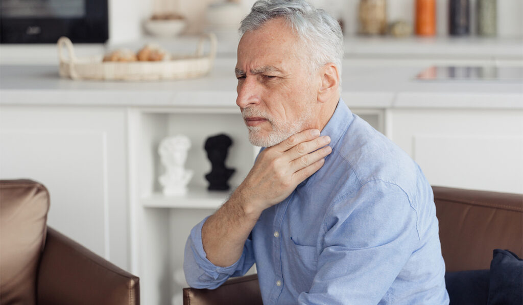 Mature man feeling sore throat with painful swallow