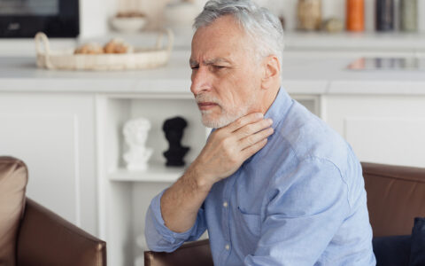 Mature man feeling sore throat with painful swallow