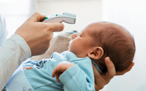 Taking a baby's temperature with a digital forehead thermometer